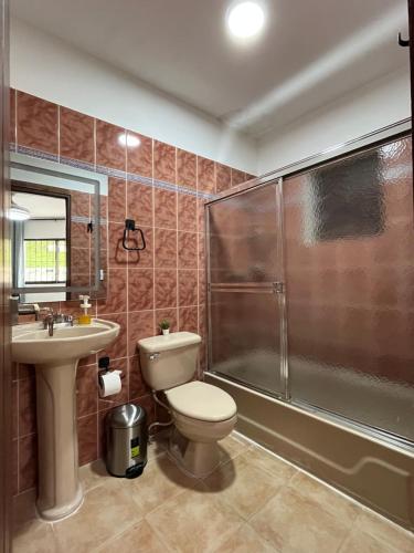 a bathroom with a toilet and a shower and a sink at Villa Colinas Del Cielo in San Cristóbal
