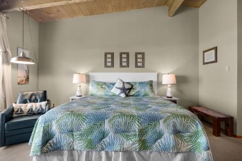 a bedroom with a large bed and a chair at The Tides by the Sea in Seaside