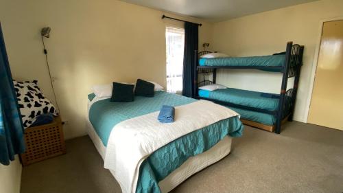 a bedroom with two beds and a bunk bed at The Lazy Cow Accommodation in Murchison