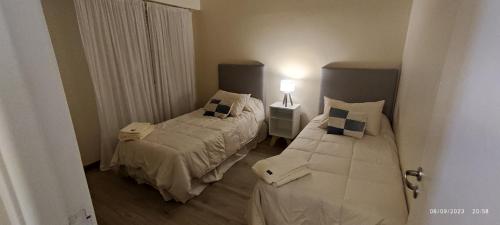 um quarto com duas camas e um candeeiro em Un departamento con historia em Buenos Aires