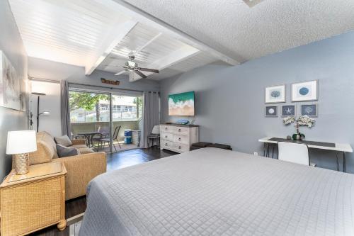 a bedroom with a bed and a living room at Kihei Bay Surf B113 in Kihei