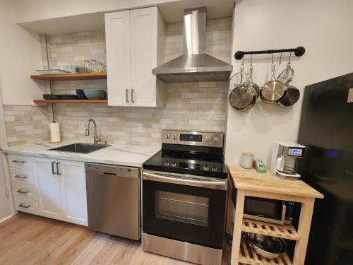 een keuken met een fornuis en een wastafel bij Elegant two bedroom with office in Montreal in Montreal