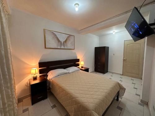 um quarto com uma cama e uma televisão de ecrã plano em LUX - HOTEL BOUTIQUE em Andahuaylas
