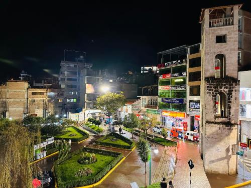 una strada trafficata di notte con edifici di LUX - HOTEL BOUTIQUE ad Andahuaylas