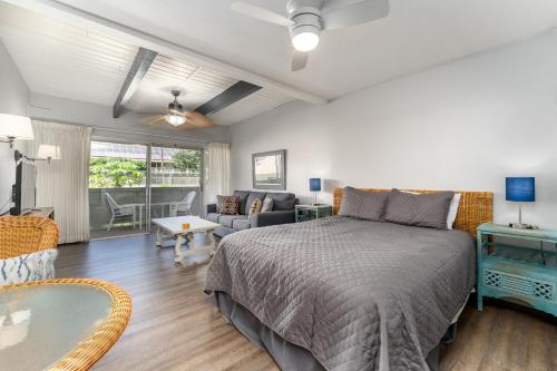 a bedroom with a bed and a living room at Kihei Bay Surf D142 A Safe Place To Stay in Kihei