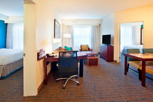 a hotel room with a bed and a desk and a bed and a bedroom at Residence Inn Baltimore Hunt Valley in Hunt Valley