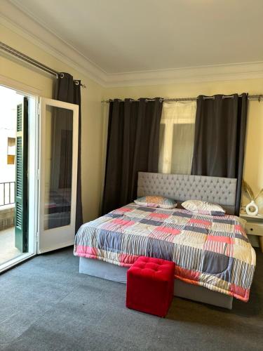 a bedroom with a bed and a red stool at Elegant room in the city center in Cairo