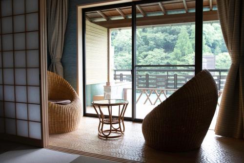 a room with two chairs and a table and a window at Senkei in Hakone