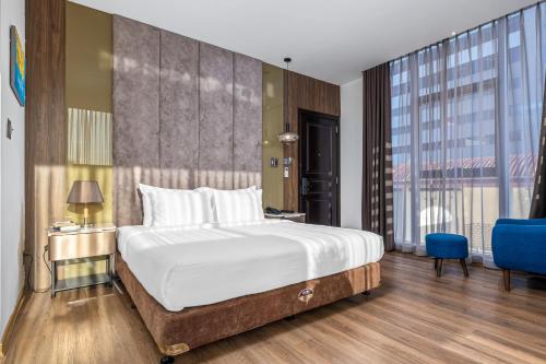 a bedroom with a large bed and a large window at Hadiva Boutique Hotel in Da Nang
