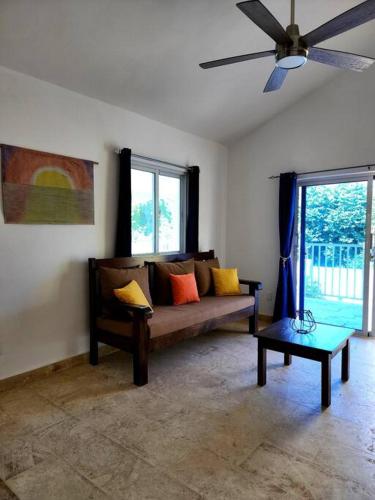 a living room with a couch and a ceiling fan at Bella Villa Roomy apartment at 5 min walk to the beach in Las Galeras