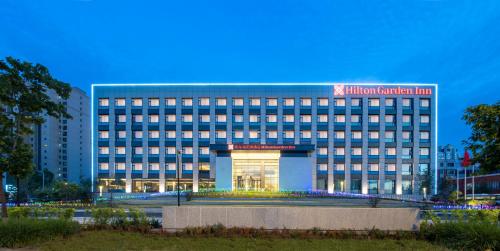 a building with a sign on the front of it at Hilton Garden Inn Changchun Economic Development Zone in Changchun