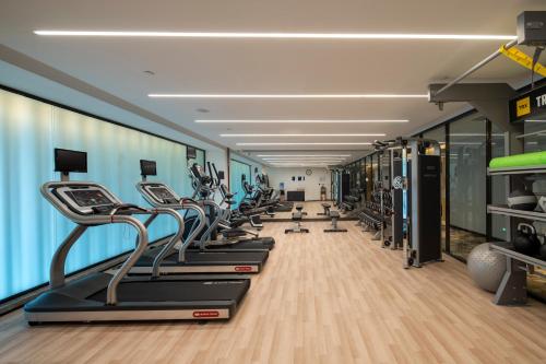 a gym with a row of treadmills and machines at Hilton Garden Inn Changchun Economic Development Zone in Changchun