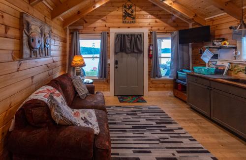 una sala de estar con sofá en una cabaña de madera en Cherokee Lake Rental en Bean Station