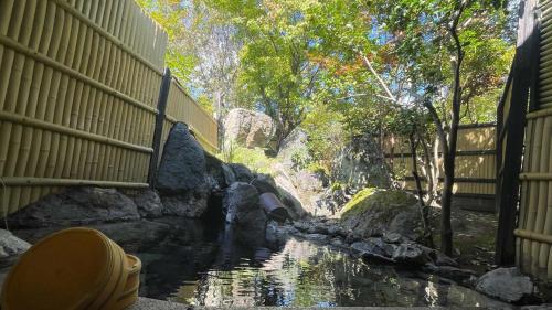 a pool of water with rocks in a zoo at Ryoso Yufuin Yamadaya in Yufuin