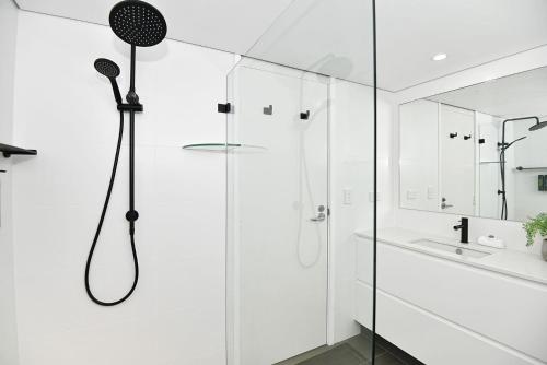 a white bathroom with a shower and a sink at Beachfront on Werrina in Blue Bay 