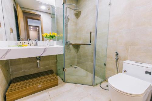 a bathroom with a shower and a toilet and a sink at Sea Villa - FLC Sam Son in Sầm Sơn