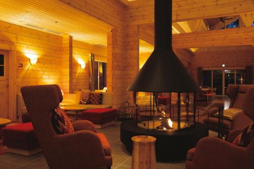 a living room with a fireplace with chairs and a table at The Prince Villa Karuizawa in Karuizawa