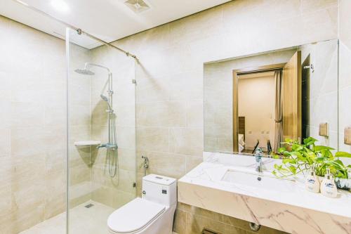 a bathroom with a shower and a toilet and a sink at Sea Villa - FLC Sam Son in Sầm Sơn