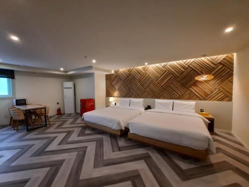 um quarto de hotel com duas camas e uma secretária em Rein Hotel Busan Yeonsan em Busan