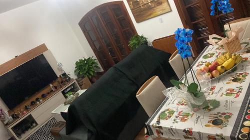 sala de estar con mesa con sillas y TV en Quarto aconchegante III en Cruzeiro