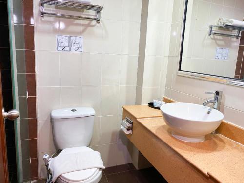 a bathroom with a toilet and a sink at Hotel Sandakan in Sandakan