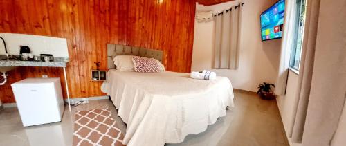 a bedroom with a bed in a room with wooden walls at ROUTE 333 in Miguel Pereira