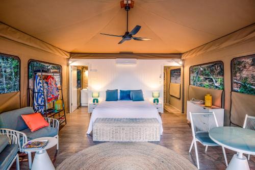 Magnetic Glamping Tent 9 في خليج نيللي: غرفة نوم بسرير وطاولة وكراسي