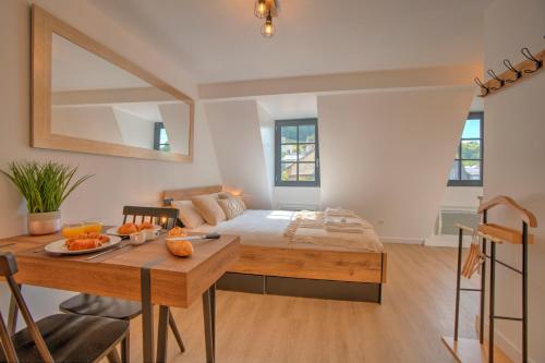 a bedroom with a bed and a table and a dining room at Le Rustique - Netflix/Wi-fi Fibre - Séjour Lozère in Mende