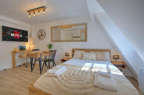 a bedroom with a bed and a desk and a table at Le Rustique - Netflix/Wi-fi Fibre - Séjour Lozère in Mende