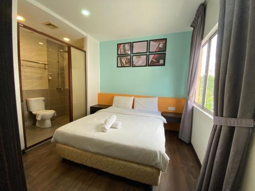 a bedroom with a bed and a shower and a toilet at Timez Business Hotel in Kuala Lumpur