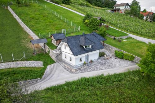 a white house with a black roof on a hill at Holiday home in Smarjeske Toplice - Kranjska Krain 45723 in Smarjeske Toplice