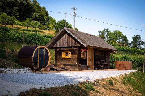 Holiday home in Otocec - Kranjska Krain 45722 في أوتوتسيك: كابينة صغيرة أمامها برميل كبير