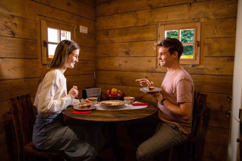 un hombre y una mujer sentados en una mesa comiendo comida en Holiday home in Otocec - Kranjska Krain 45722, en Otočec