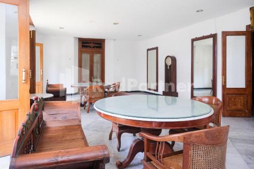 a dining room with a glass table and wooden chairs at Hotel Limaran 1 Syariah Malioboro Mitra RedDoorz in Sentool