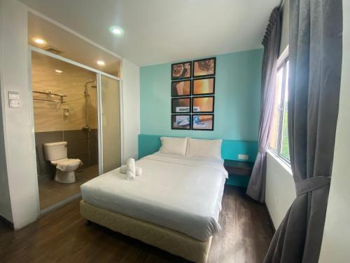 a bedroom with a large bed and a bathroom at Timez Business Hotel in Kuala Lumpur