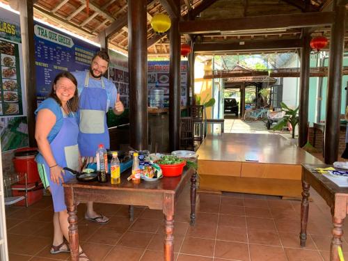 a man and a woman standing in front of a table at Tra Que Green Villa Hoi An in Hoi An