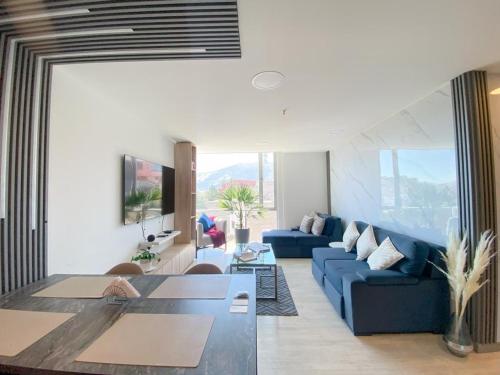 a living room with a blue couch and a table at Dpo 2 dorm(parqueadero wifi Netflix)vista pan. UIO in Quito
