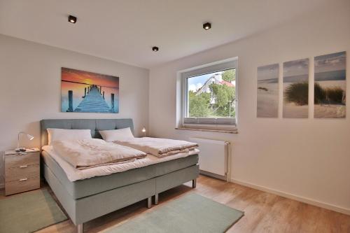 a bedroom with a bed and two windows at Haus am Seehof 9 Ferienwohnung Ostseeliebe Nr 3 in Sierksdorf