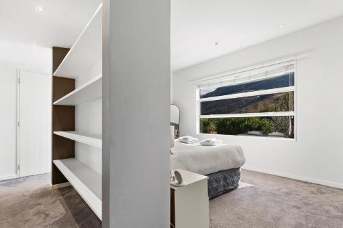 a bedroom with a bed and a window at Whakata on McBride in Queenstown