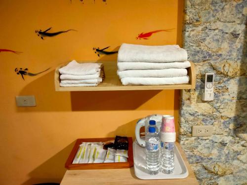 einen Haufen Handtücher auf einem Regal im Bad in der Unterkunft Jiji Fuli Homestay in Jiji