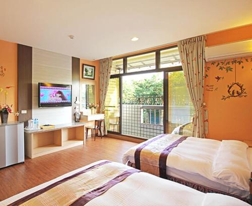 ein Hotelzimmer mit 2 Betten und einem TV in der Unterkunft Jiji Fuli Homestay in Jiji