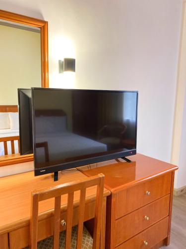 a flat screen tv sitting on top of a wooden dresser at Hotel Sandakan in Sandakan