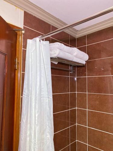 a bathroom with a shower with a white shower curtain at Hotel Sandakan in Sandakan