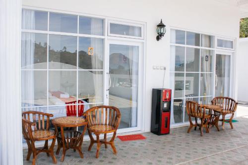 a room with a table and chairs and a soda machine at RedDoorz Syariah near Kawasan Wisata Gunung Prau Dieng in Dieng