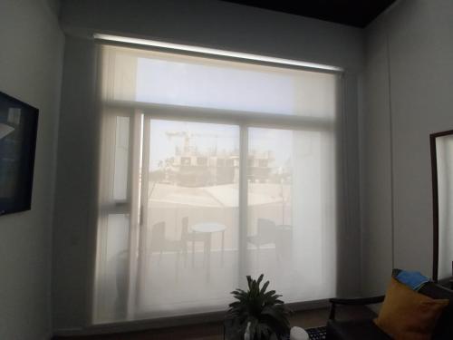a window with a white curtain in a living room at Lovely and Peaceful Home in Guatemala
