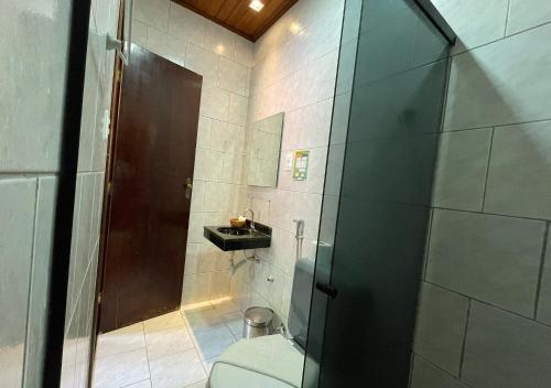 a bathroom with a shower with a toilet and a sink at Pousada Estevao in Morro de São Paulo