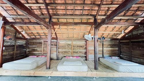 a room with two beds in a wooden ceiling at Thôn Hoa Sen in Thôn Xuân Lỗ