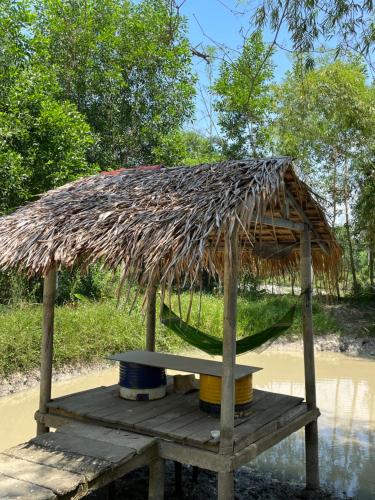 a small hut with a table and a straw roof at Thôn Hoa Sen in Thôn Xuân Lỗ