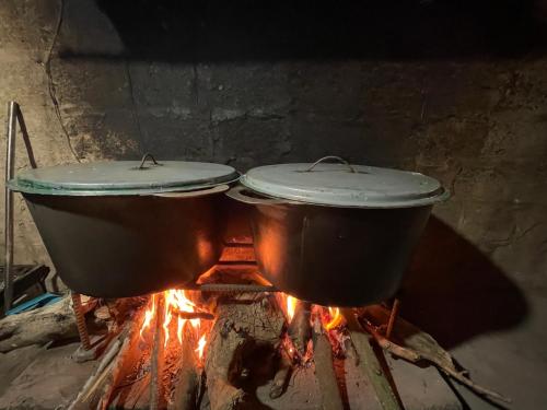 two pots sitting on top of a fire at Thôn Hoa Sen in Thôn Xuân Lỗ