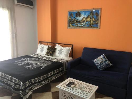 mały pokój z łóżkiem i kanapą w obiekcie Exoticky apartman w mieście Hurghada